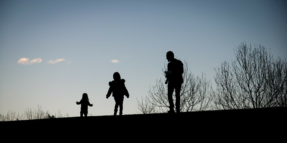 Silhouette of family against evening sky in park