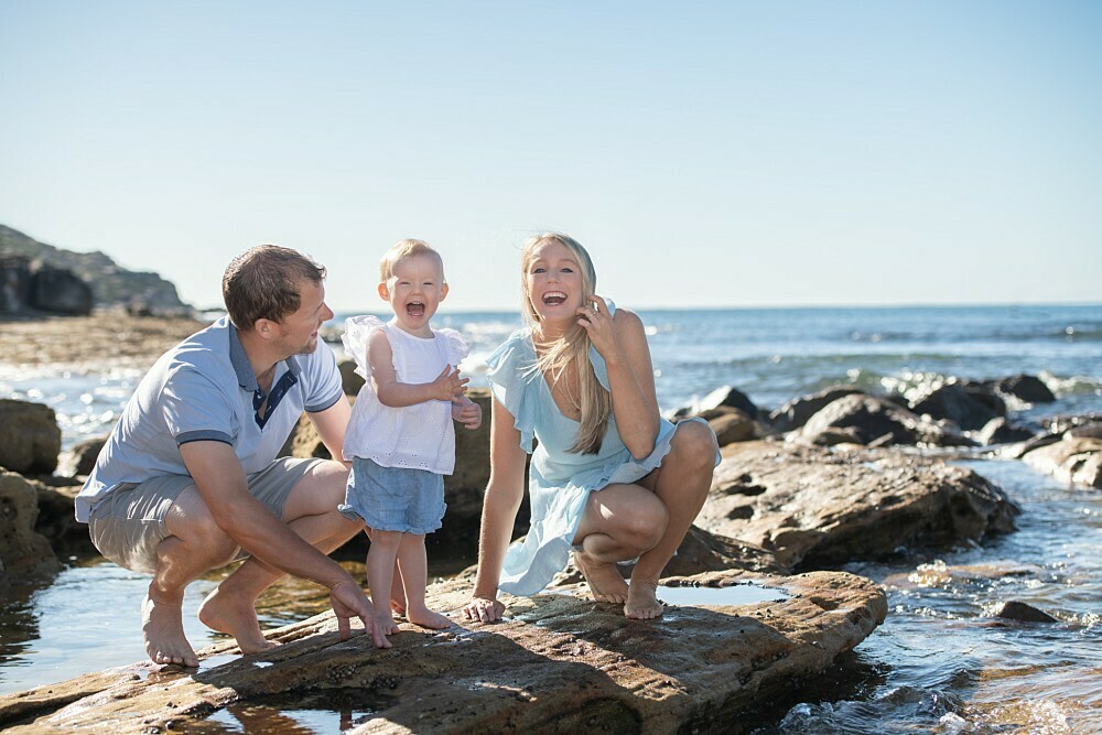 Family with small girl on rocks at Malabar Beach Sydney