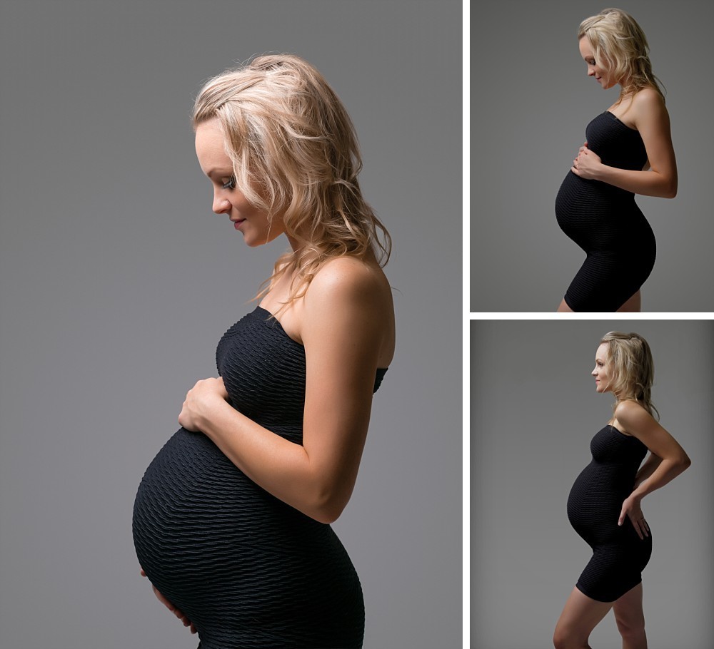 Pregnant blonde woman in black dress looking at belly in Sydney studio