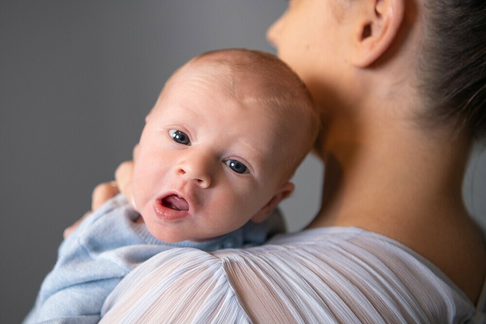 Baby looking over mum's shoulder in Newborn Photography Sydney