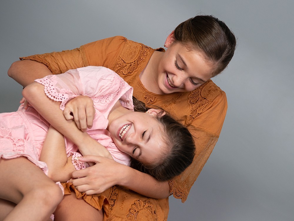 Sisters playing and laughing in family photography in Sydney studio