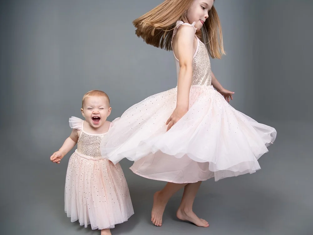 Girl in tutu dancing with toddler